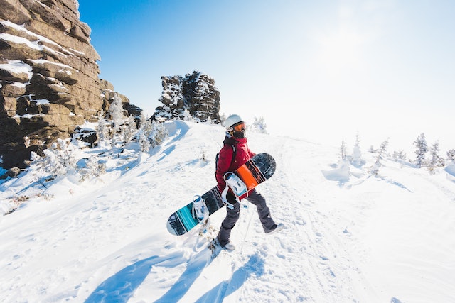 a-person-in-red-jacket-holding-snowboard