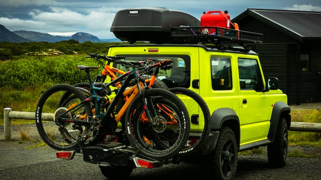 bicycles are attached to a yellow jeep