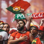 a-group-of-people-holding-up-signs-and-flags