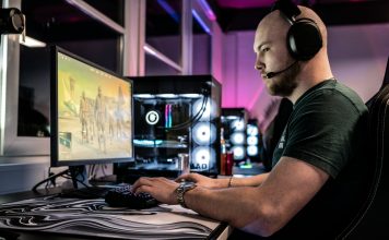 Guide to the 10 Best Gaming Blogs for Lore a-man-sitting-in-front-of-a-computer-with-headphones